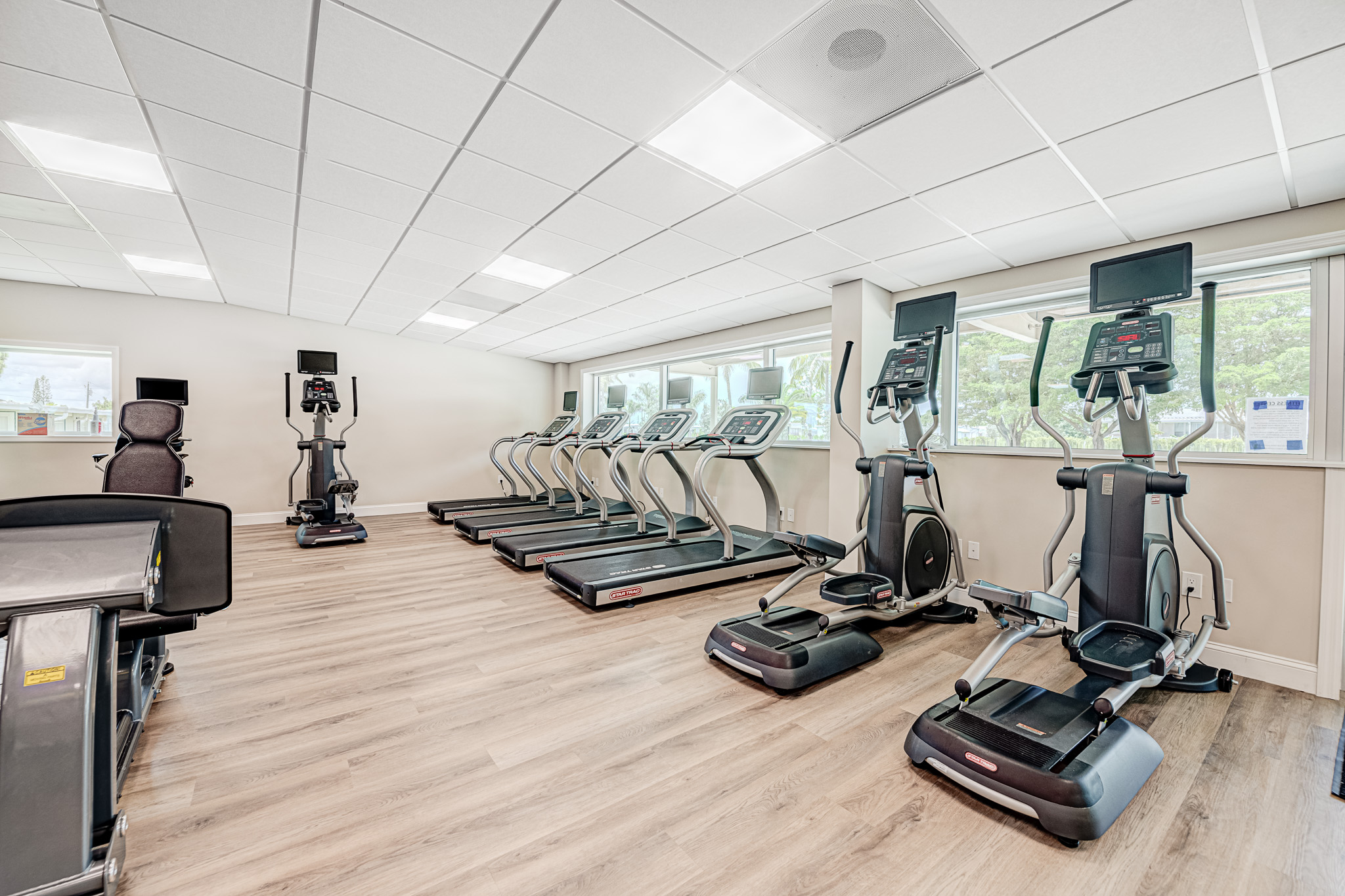 Treadmills and other cardio exercise machines on the wooden floors of Bonita Terra's Fitness Room
