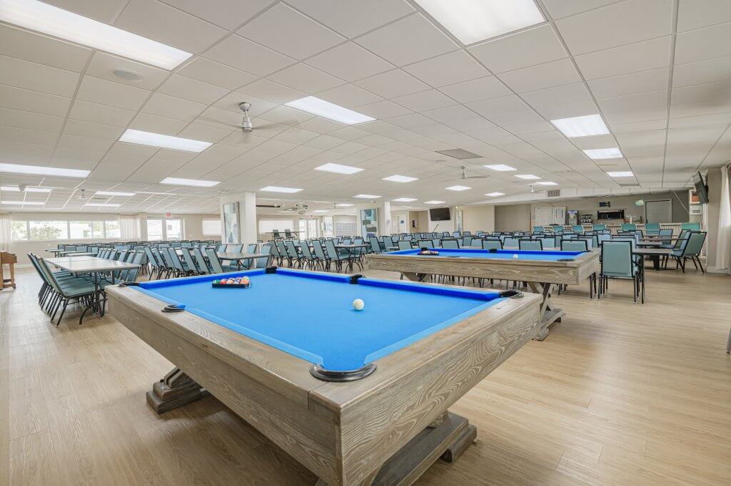 Manufactured home expansive indoor recreational hall featuring blue billiard tables
